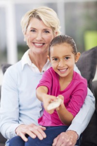 little girl watching television with her grandma